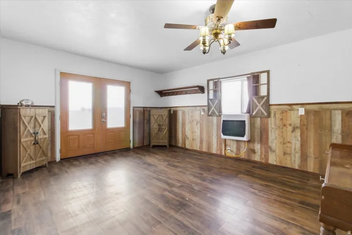 Foyer with a wainscoted wall, wooden walls, heating unit, healthy amount of natural light, and dark wood finished floors
