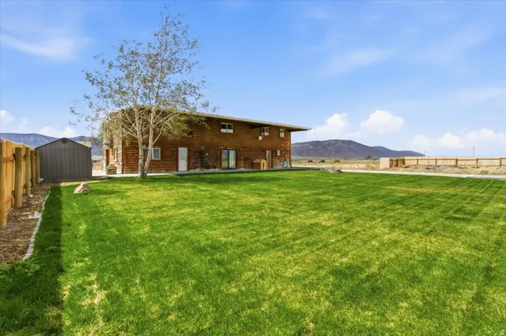 Rear view of house with a mountain view and a storage shed