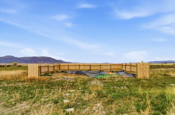 Fenced yard featuring a mountain view and a view of rural / pastoral area