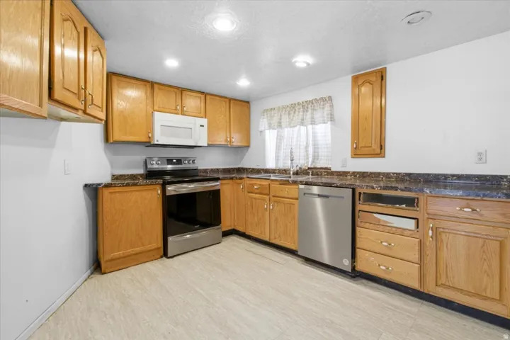 Kitchen with stainless steel appliances, wood finish cabinetry, and recessed lighting