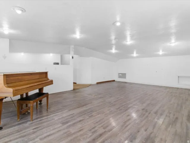 Miscellaneous room with light wood-style flooring and lofted ceiling