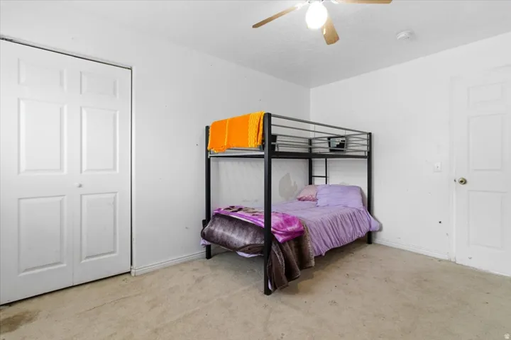 Bedroom with light carpet and a ceiling fan