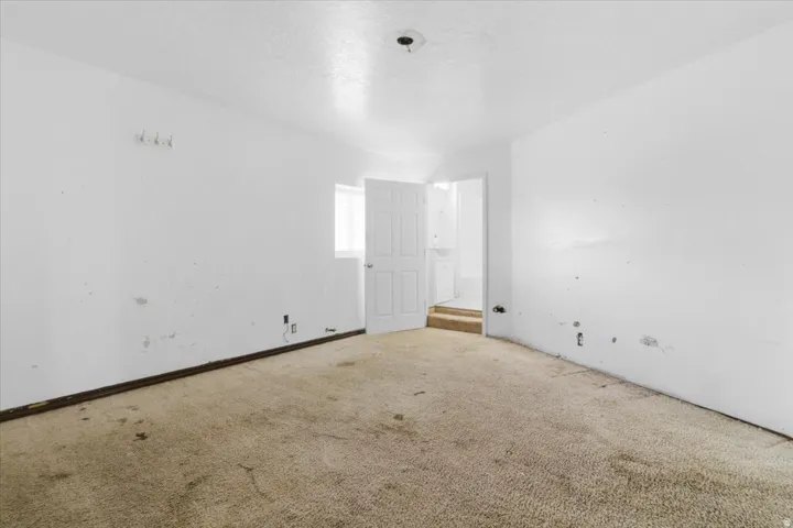 Carpeted spare room featuring a textured ceiling