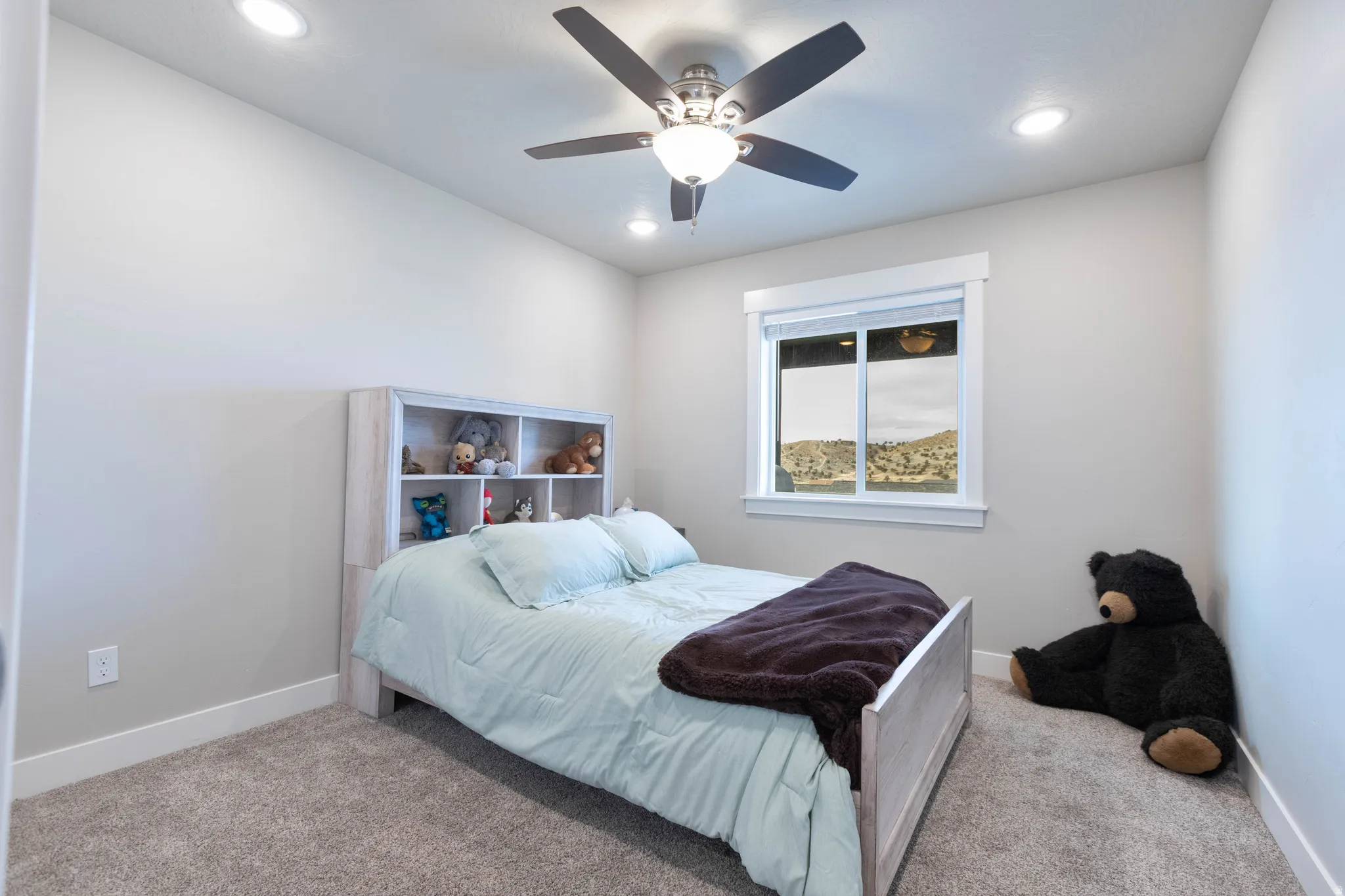 Carpeted bedroom featuring a ceiling fan and recessed lighting