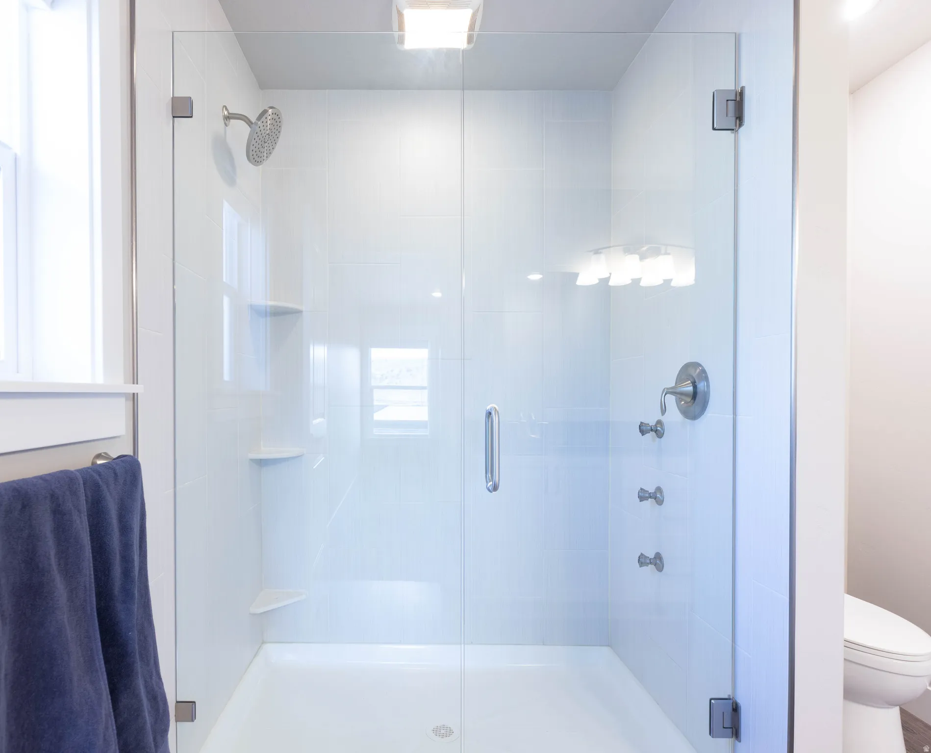 Bathroom featuring a shower stall and toilet