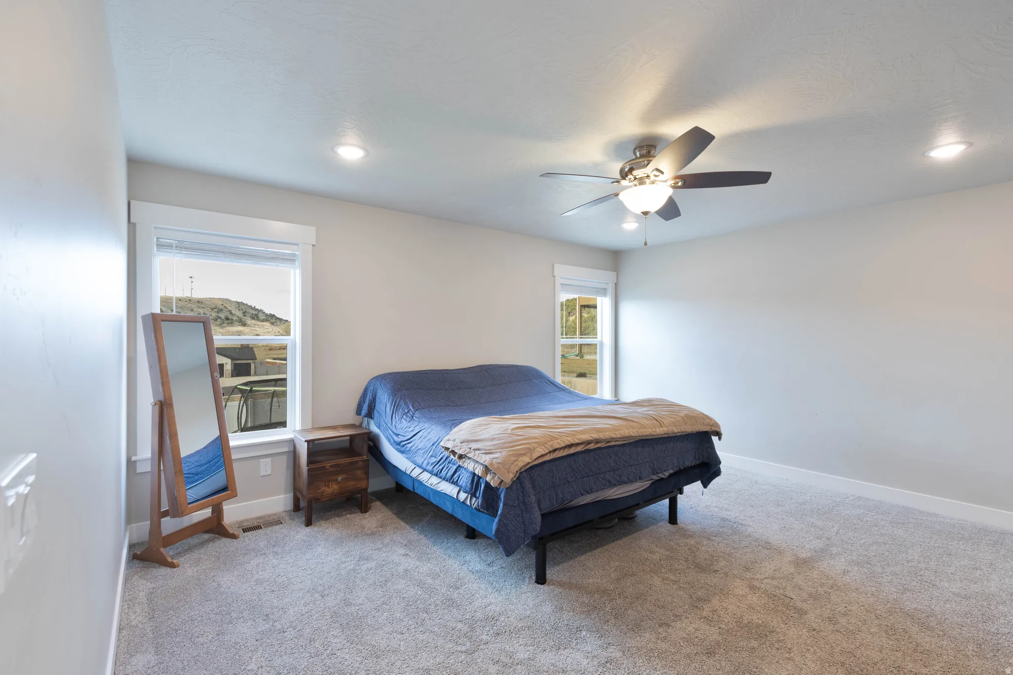 Bedroom with light colored carpet, a ceiling fan, and recessed lighting
