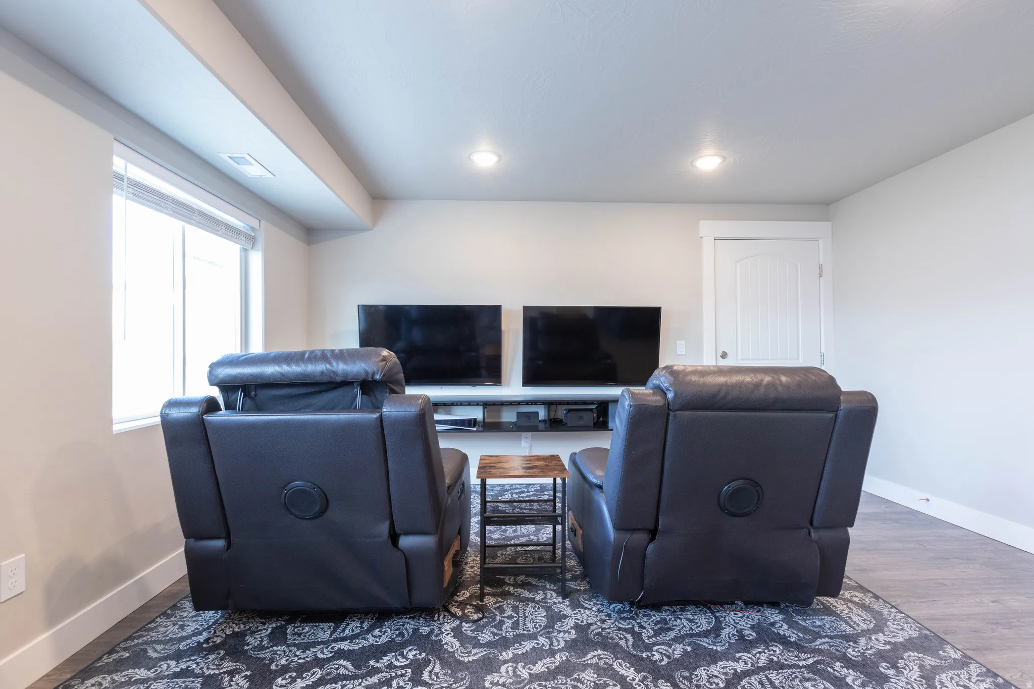 Living area with wood finished floors and recessed lighting