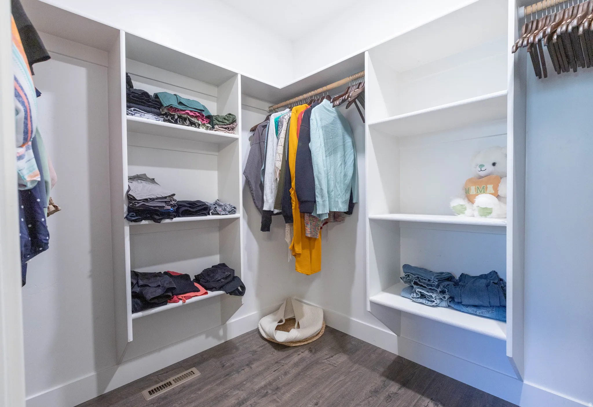 Walk in closet with dark wood-type flooring