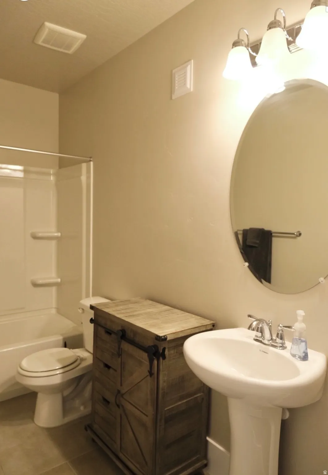 Bathroom with bathtub / shower combination and tile patterned floors