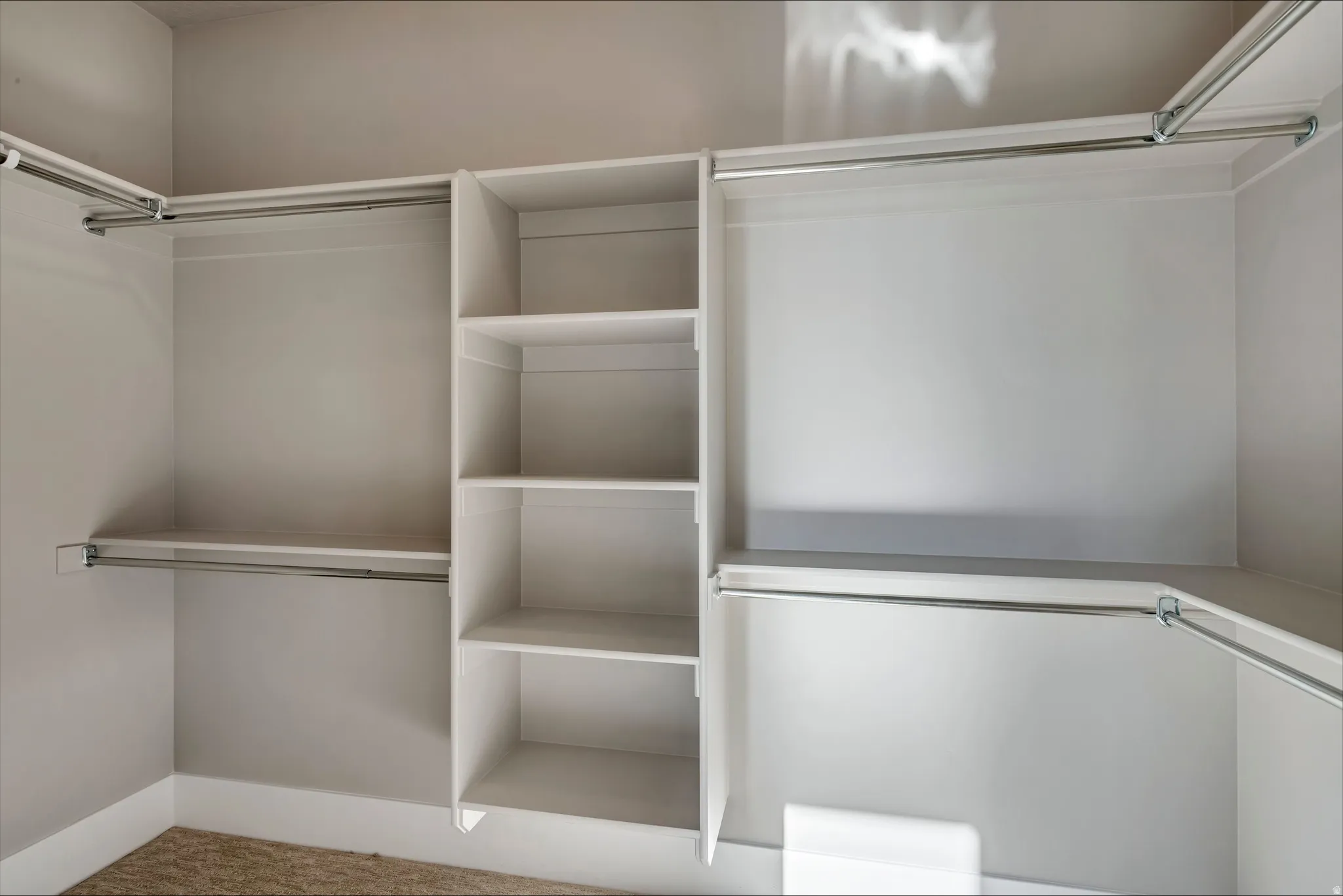 Walk in closet featuring light colored carpet