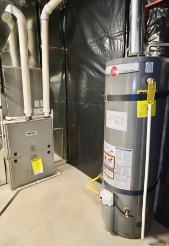 Utility room featuring secured 40-Gallon water heater and heating unit