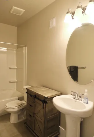 Bathroom with bathtub / shower combination and tile patterned floors
