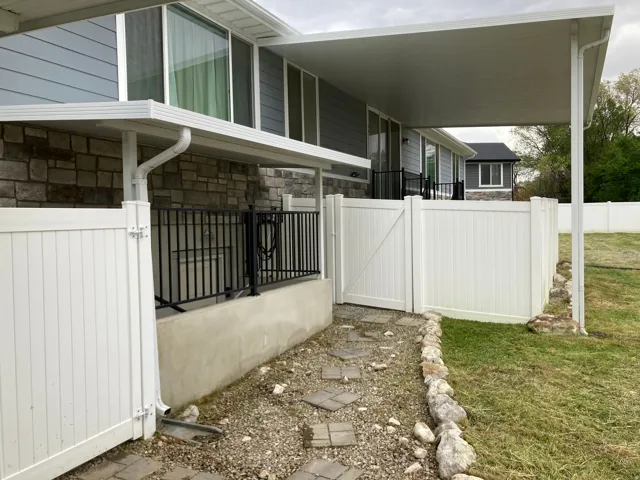 View of side of property with stone siding and a gate