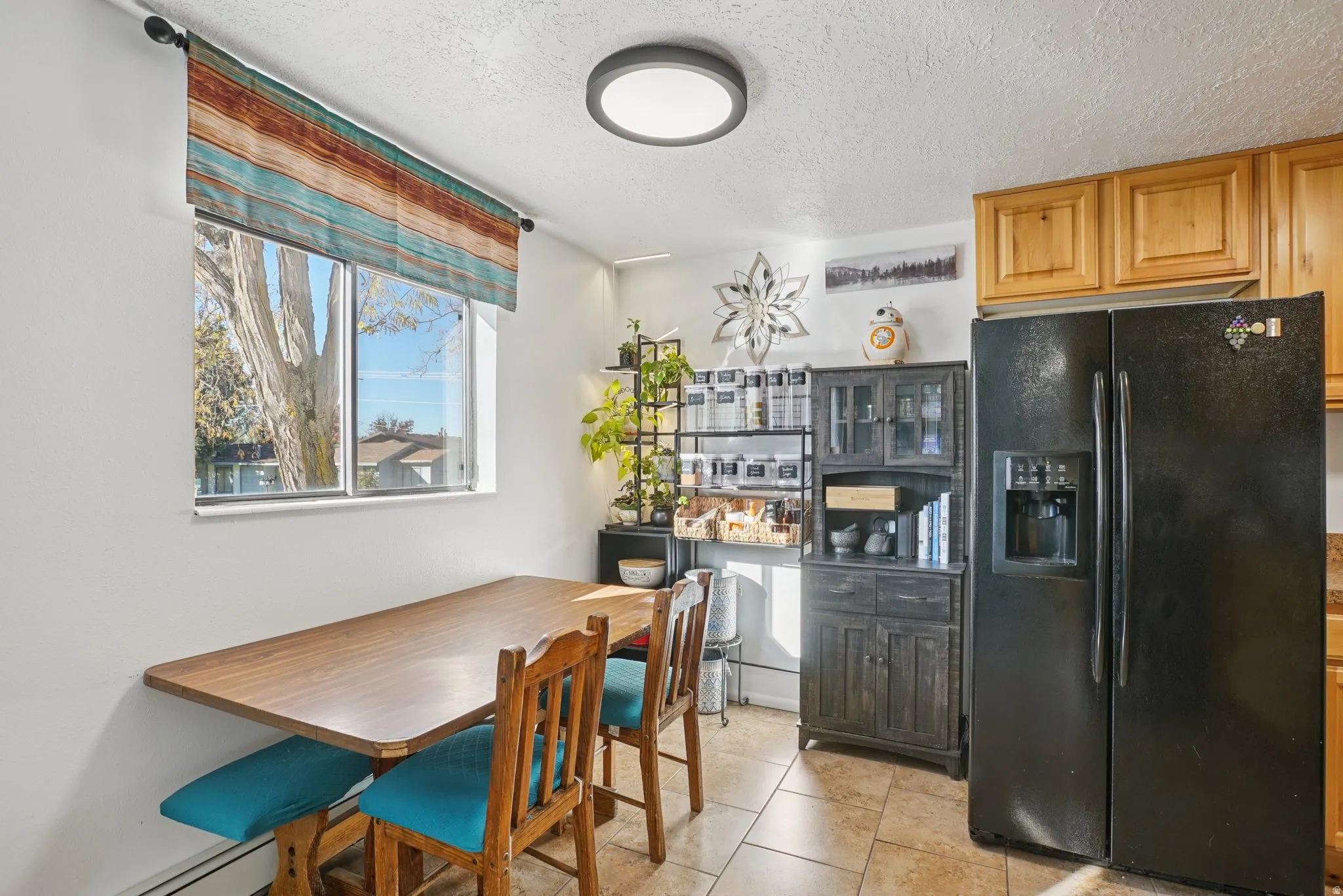 Dining area featuring a textured ceiling and light tile patterned flooring
