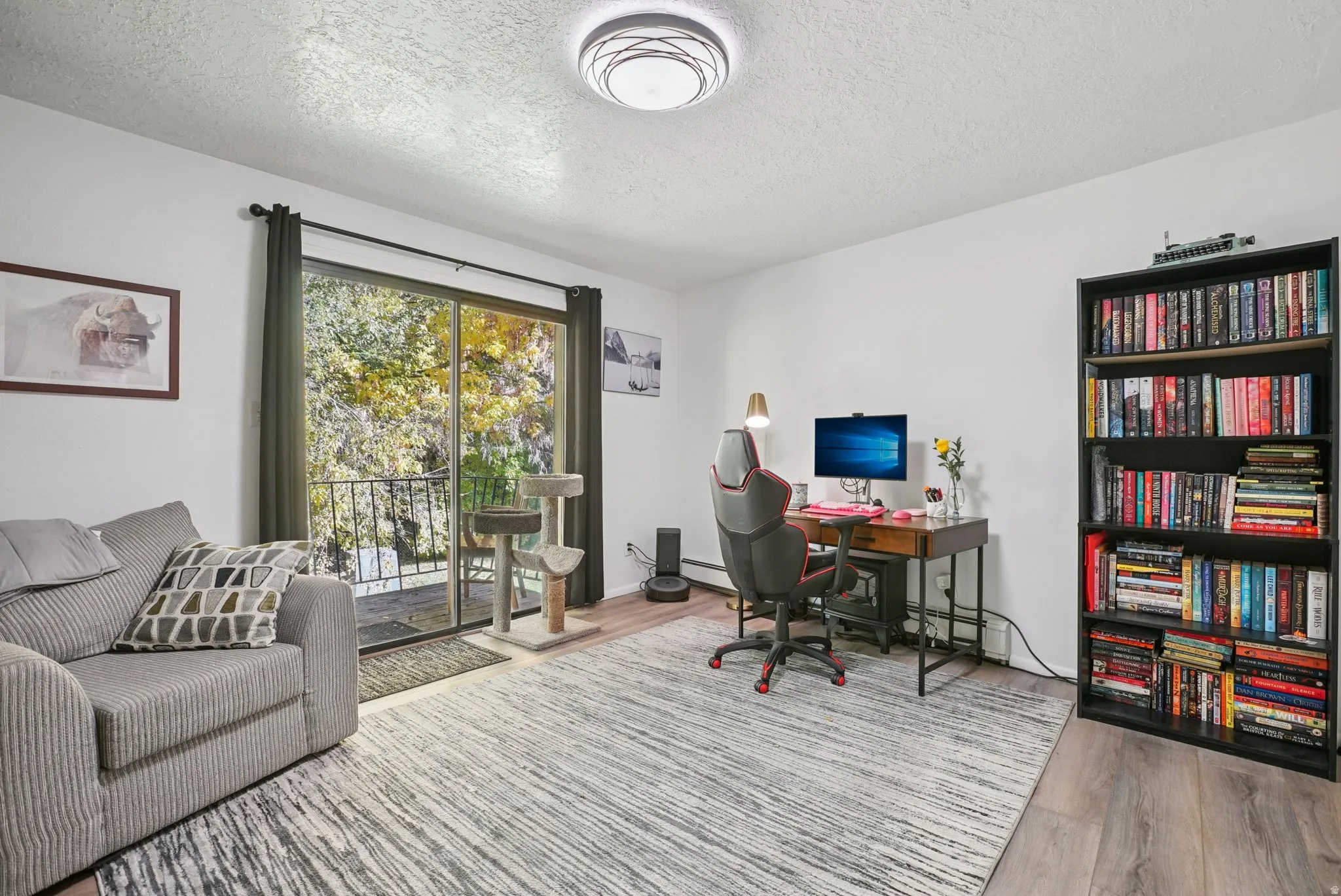 Office space with a textured ceiling, light wood-style flooring, and baseboard heating