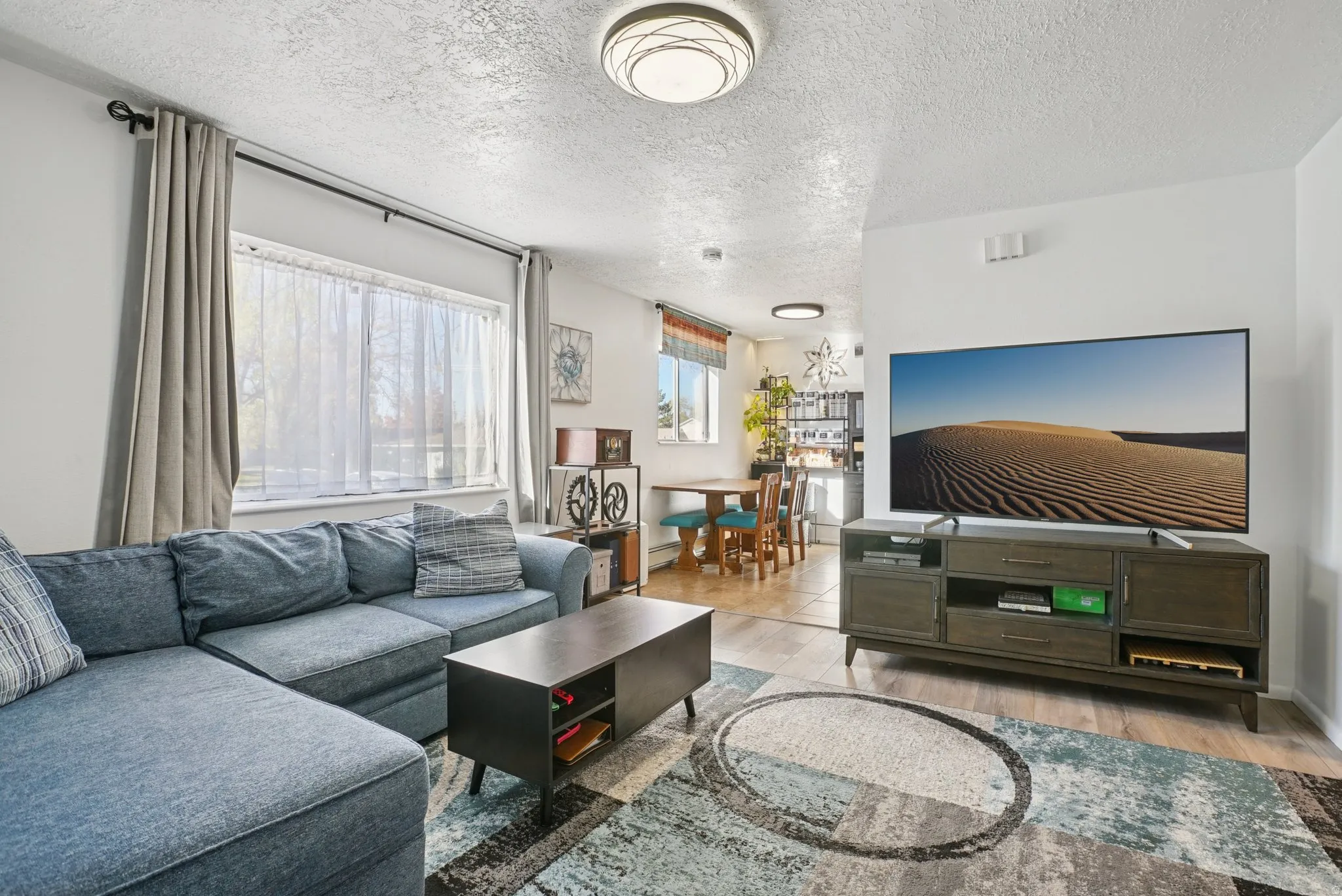Living room featuring light wood-type flooring and a textured ceiling