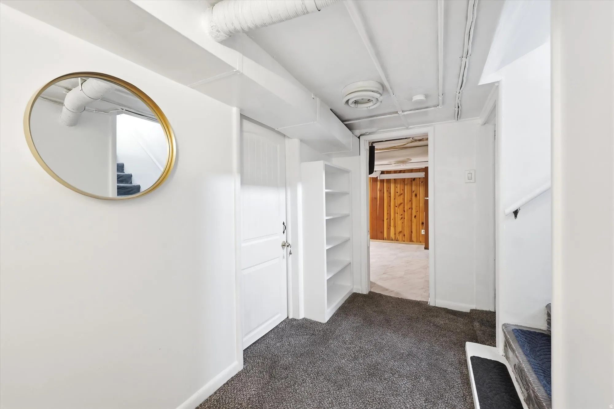 Hallway with dark carpet and baseboards