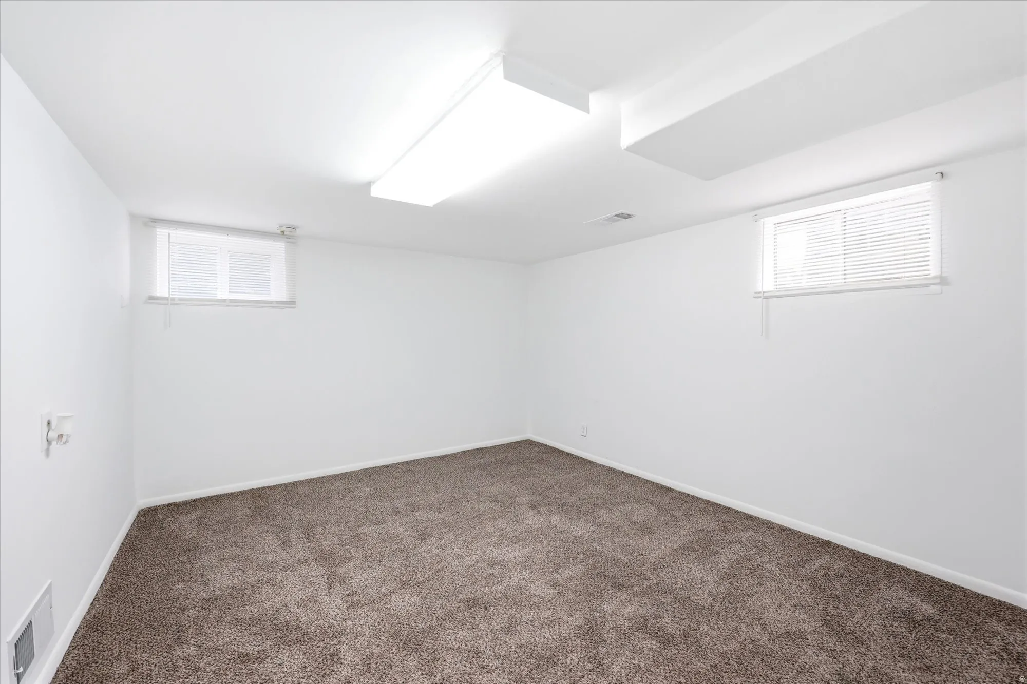Below grade area with dark carpet and baseboards