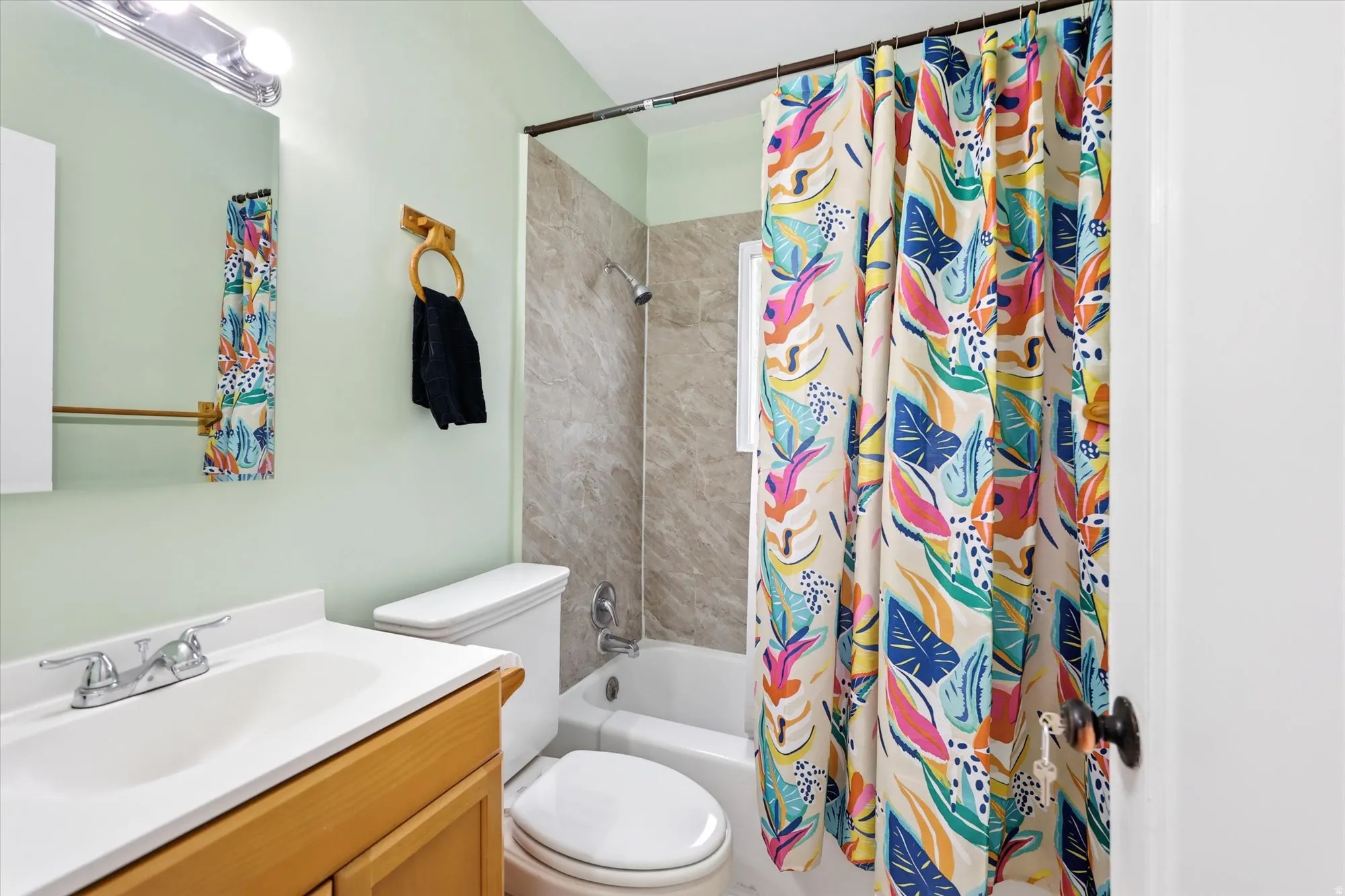 Bathroom with vanity and shower / bath combination with curtain