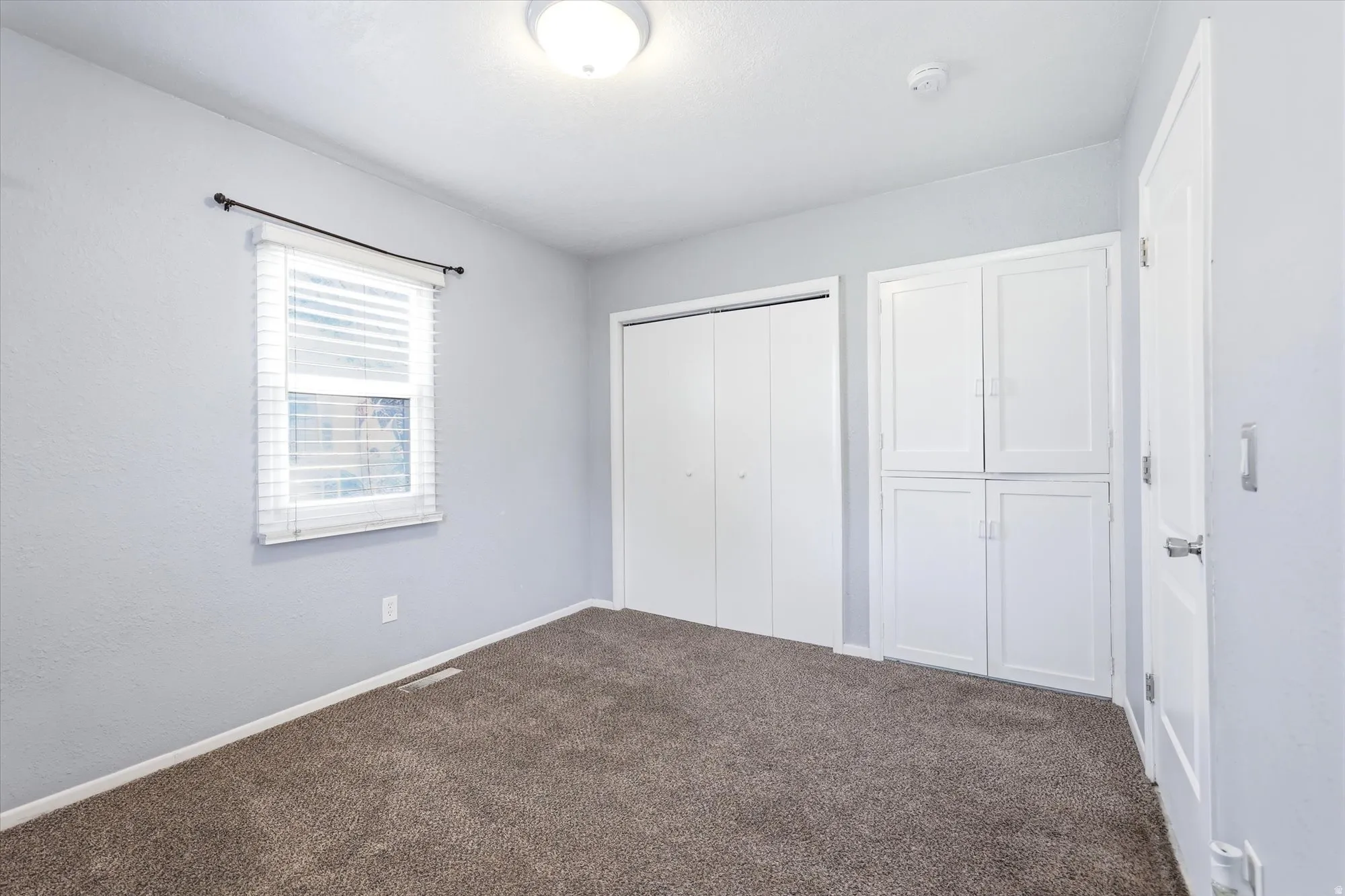 Unfurnished bedroom with dark colored carpet and a closet