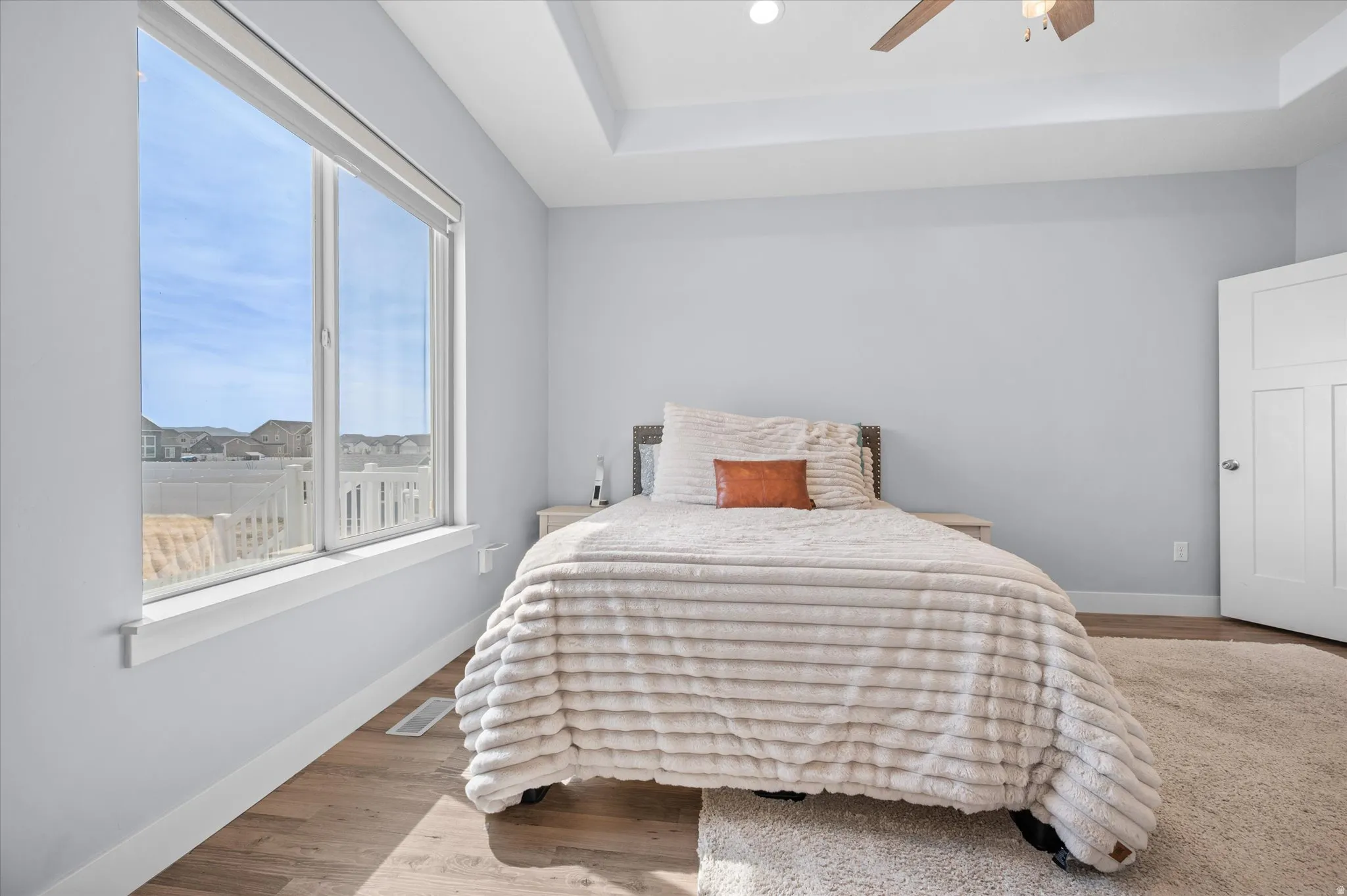 Bedroom featuring a tray ceiling, wood finished floors, ceiling fan, and recessed lighting