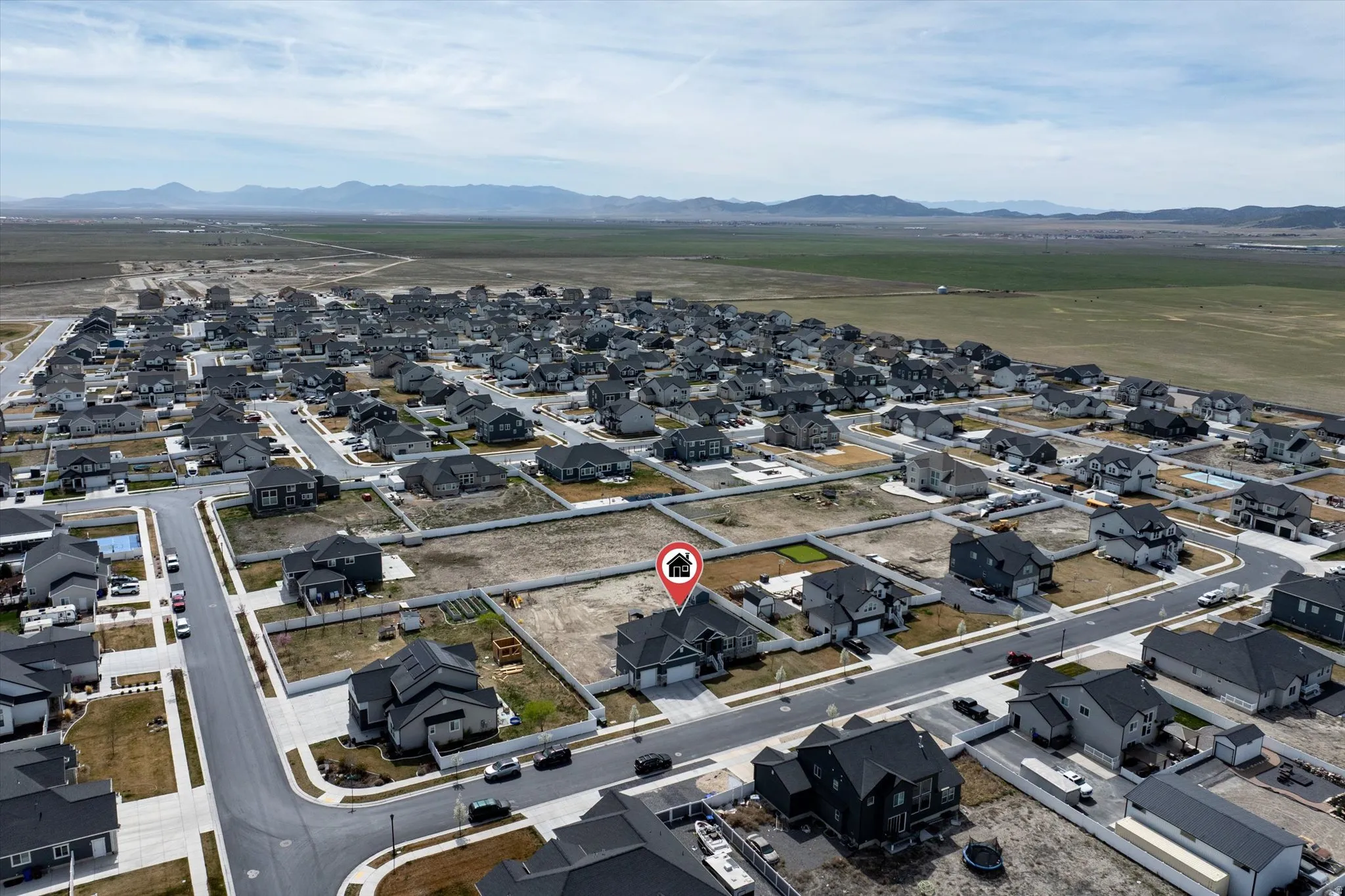 Aerial view of property's location with nearby suburban area and a mountainous background