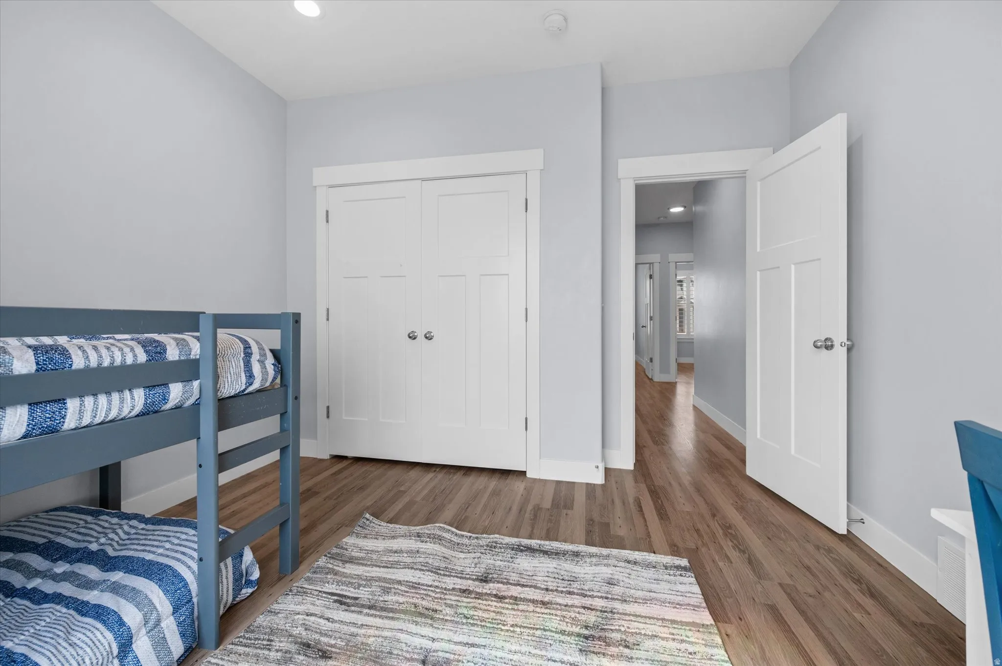 Bedroom with wood finished floors, recessed lighting, ceiling fan and a closet