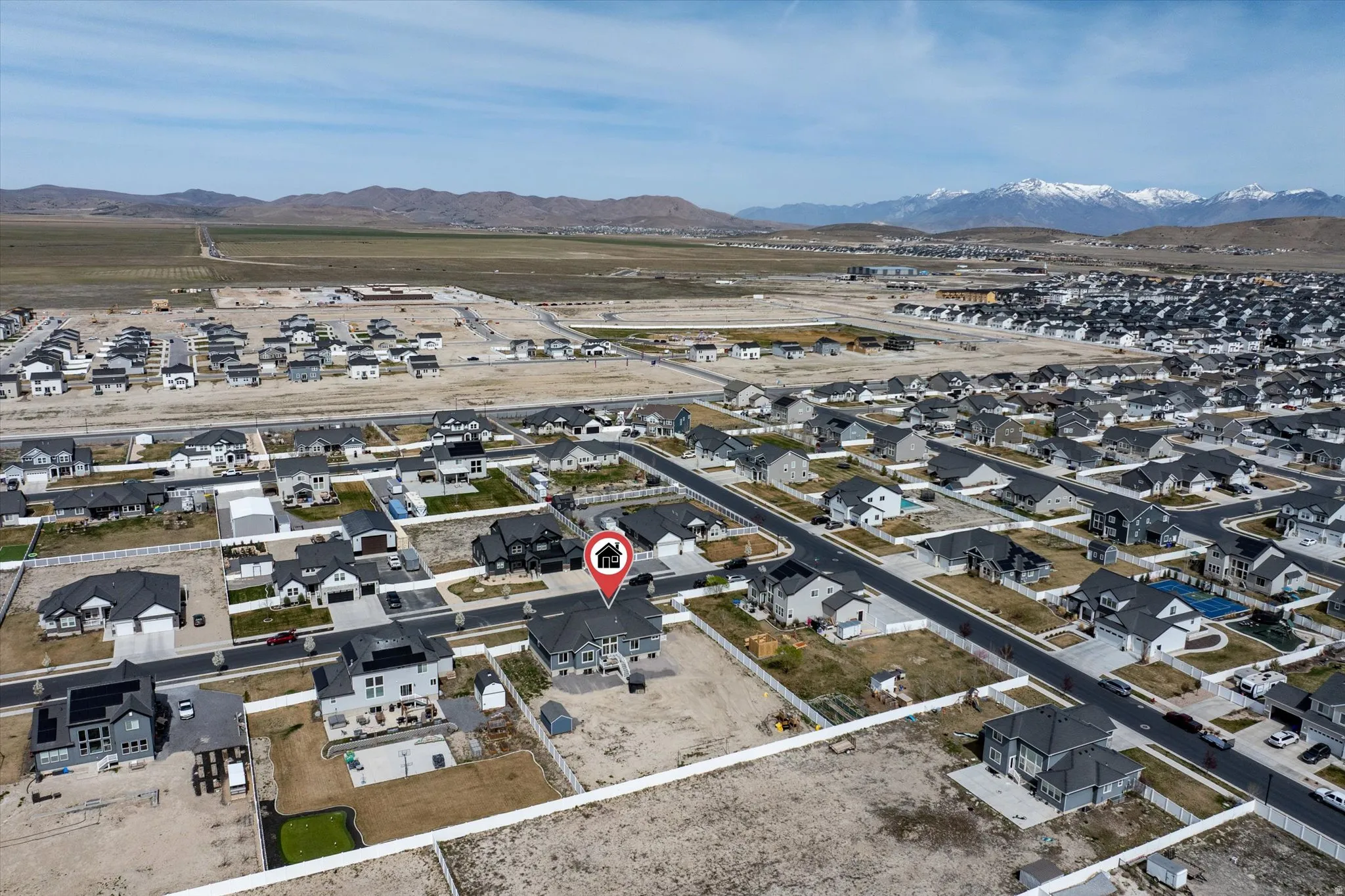 Aerial view of property and surrounding area featuring nearby suburban area and a mountainous background
