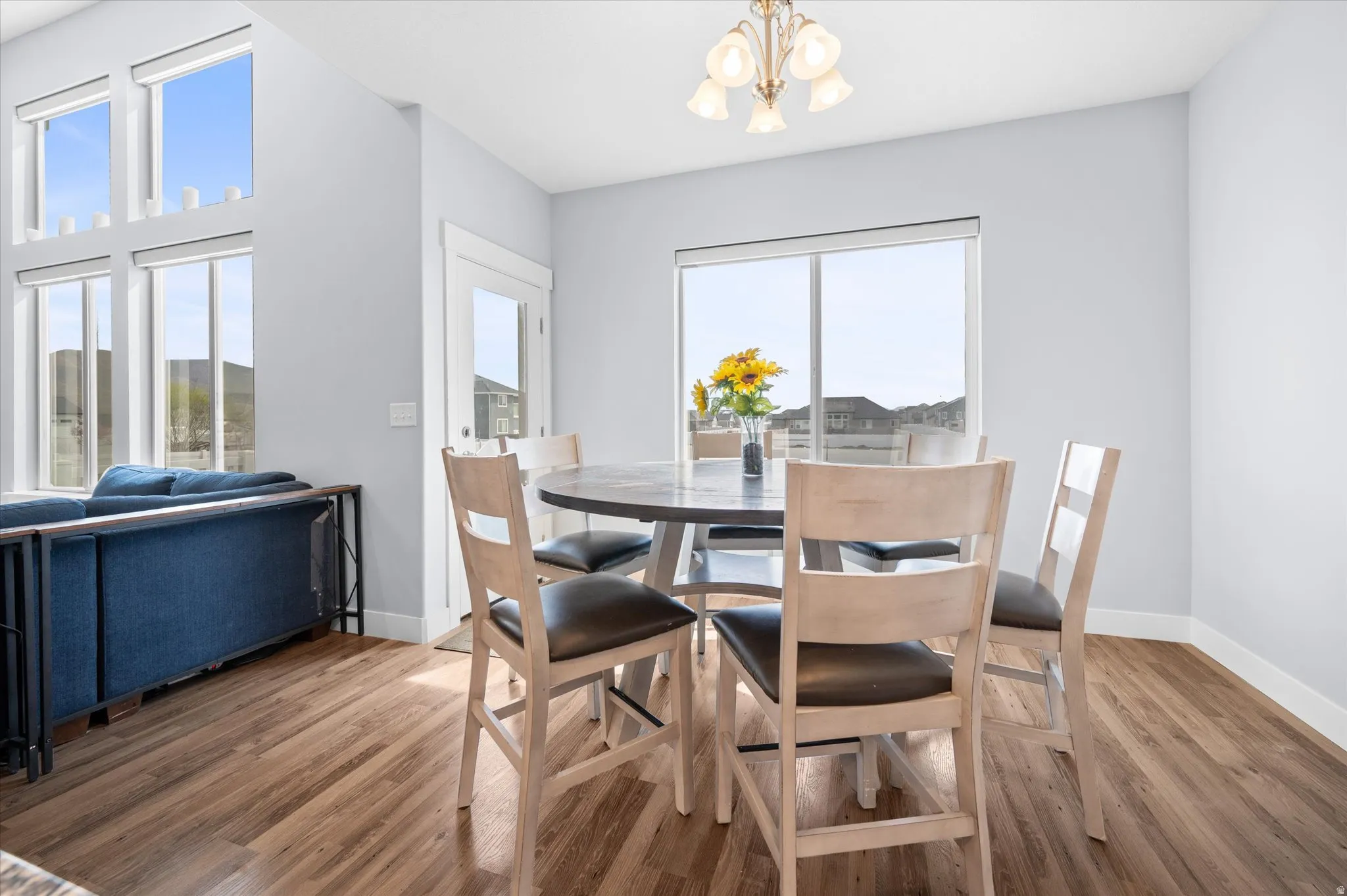 Dining space with suspended lighting and wood finished floors