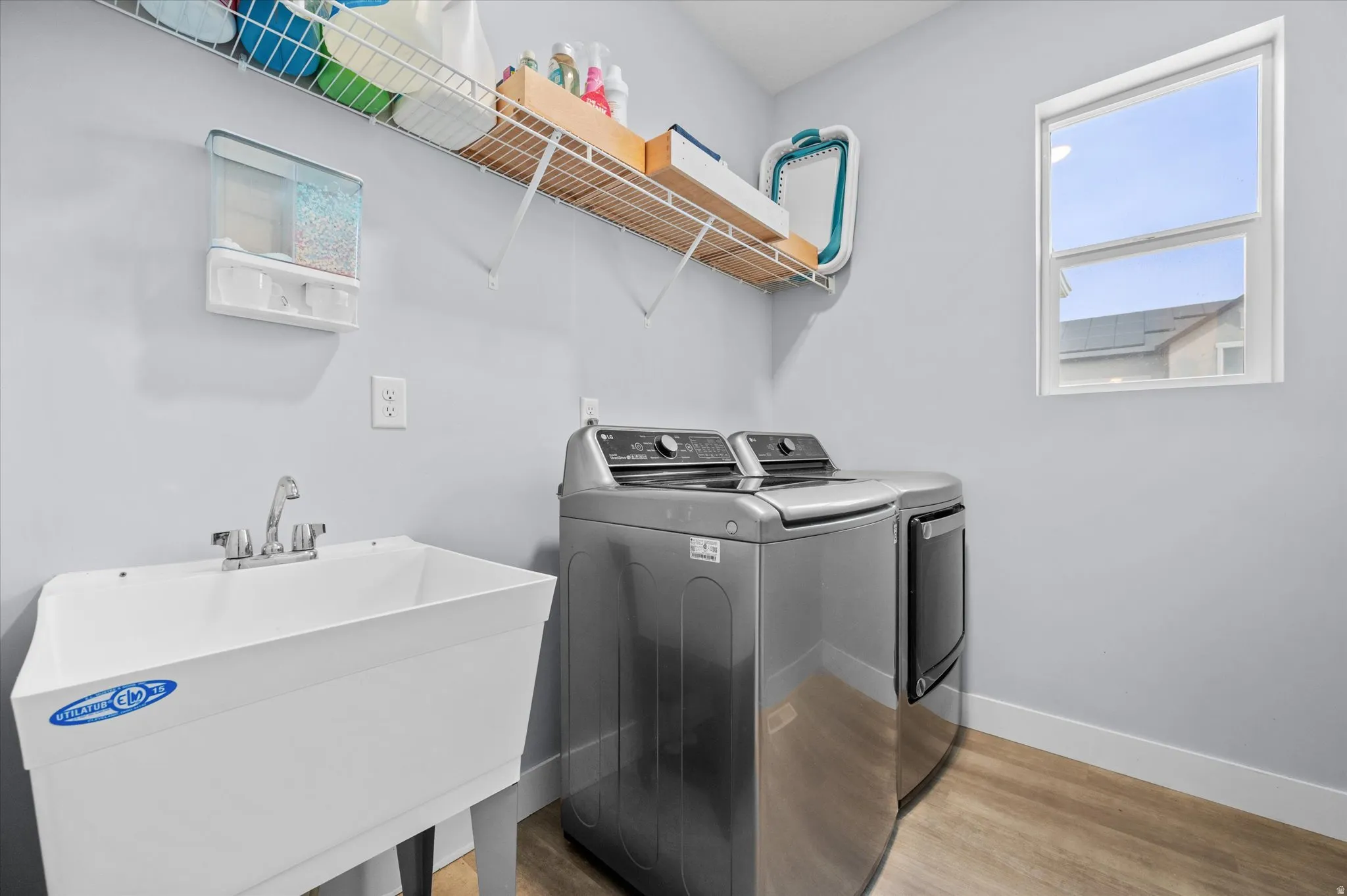 Laundry room featuring separate washer and dryer and light wood-style floors and sink