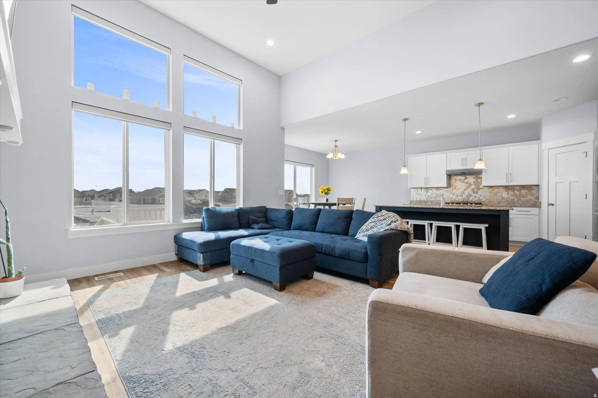 Living room featuring wood finished floors, a cathedral ceiling, fan and recessed lighting