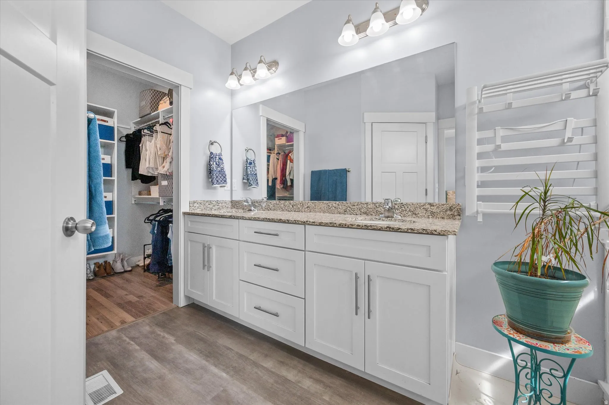 Bathroom featuring double vanity and light wood-style floors