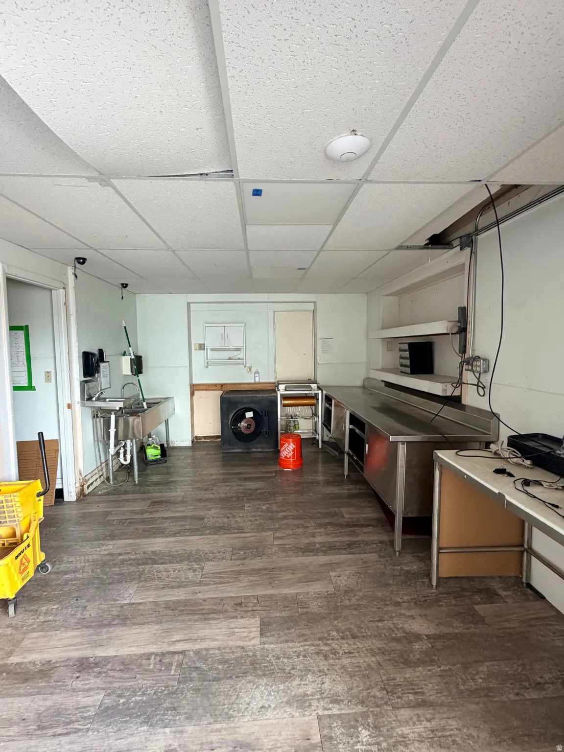 Kitchen featuring a paneled ceiling and dark wood-type flooring