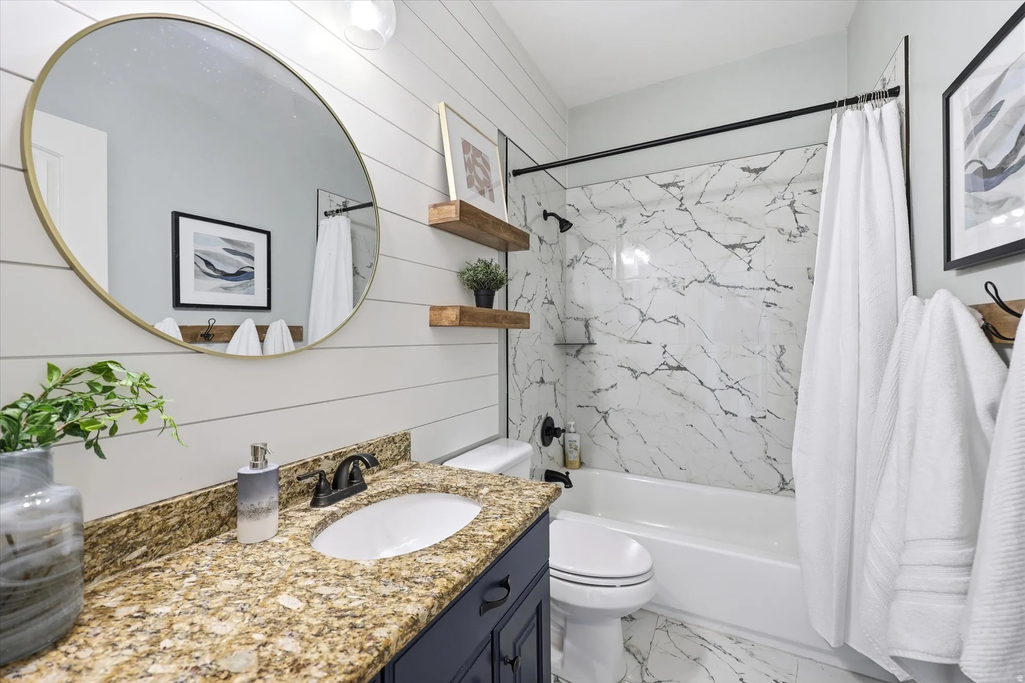Bathroom featuring vanity, wooden walls, shower / tub combo, and light marble finish floors