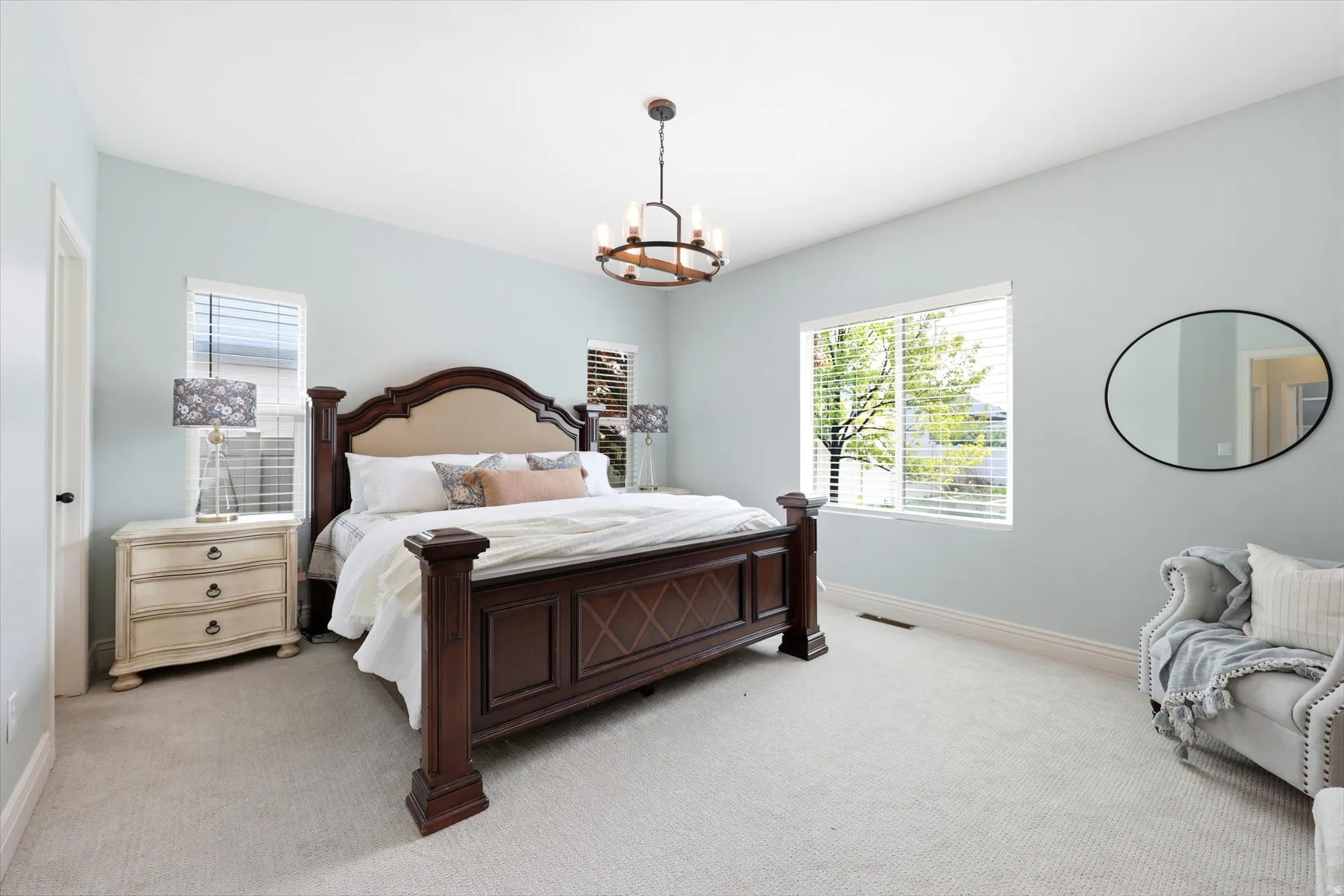 Bedroom featuring light colored carpet and suspended lighting