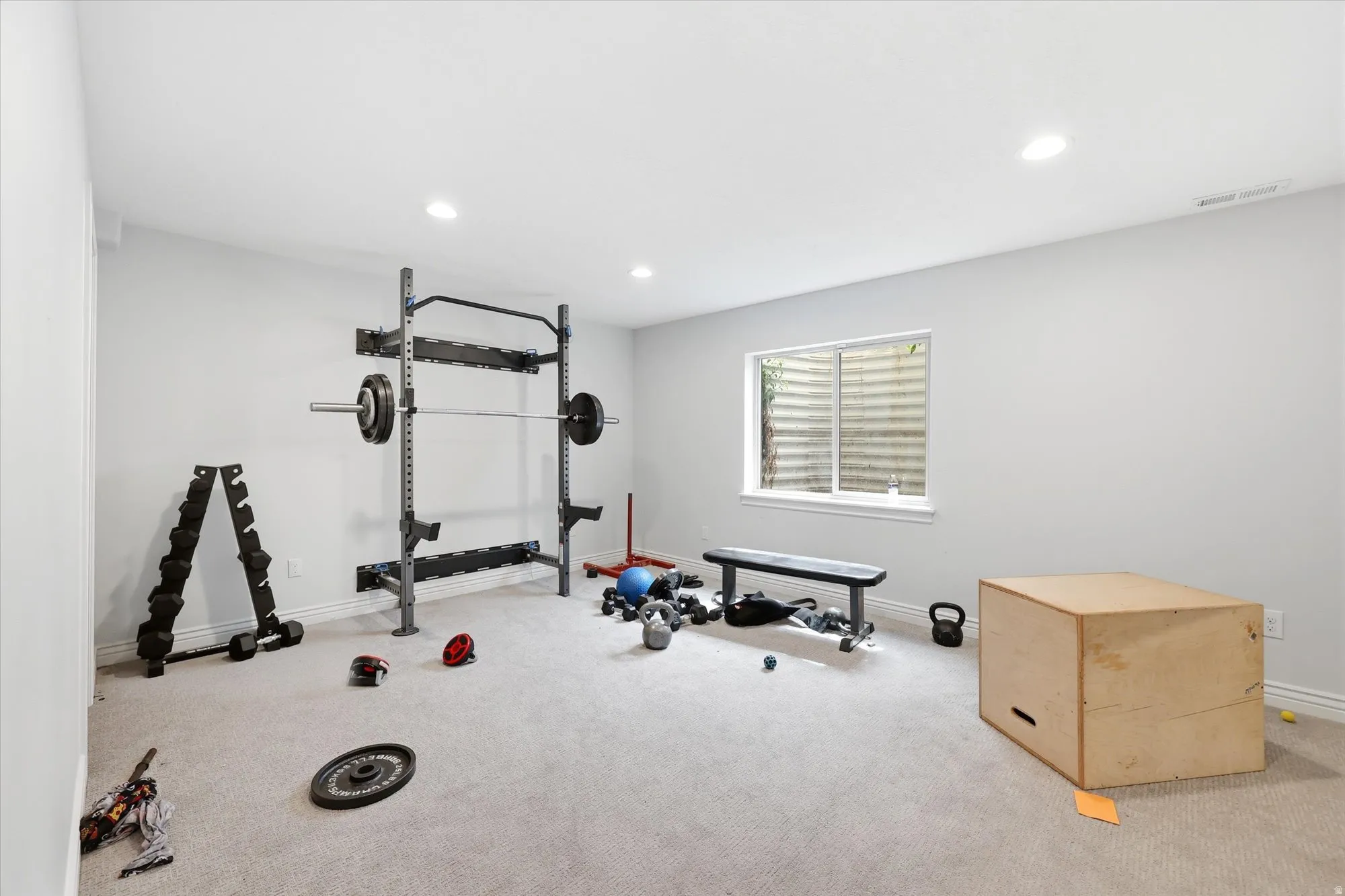 Workout room with light colored carpet and recessed lighting