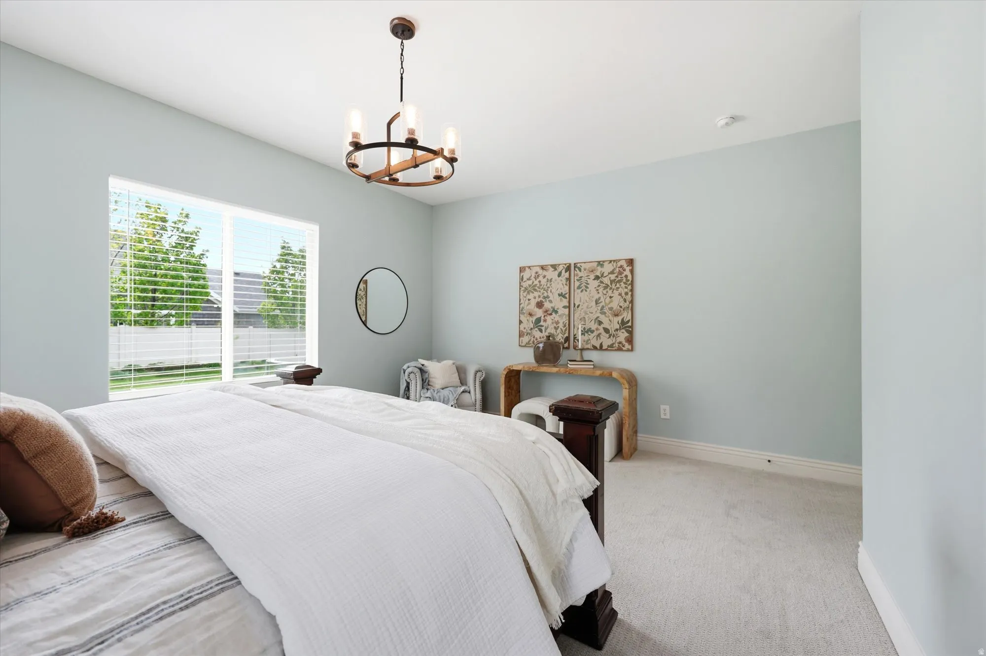 Bedroom with suspended lighting and light carpet