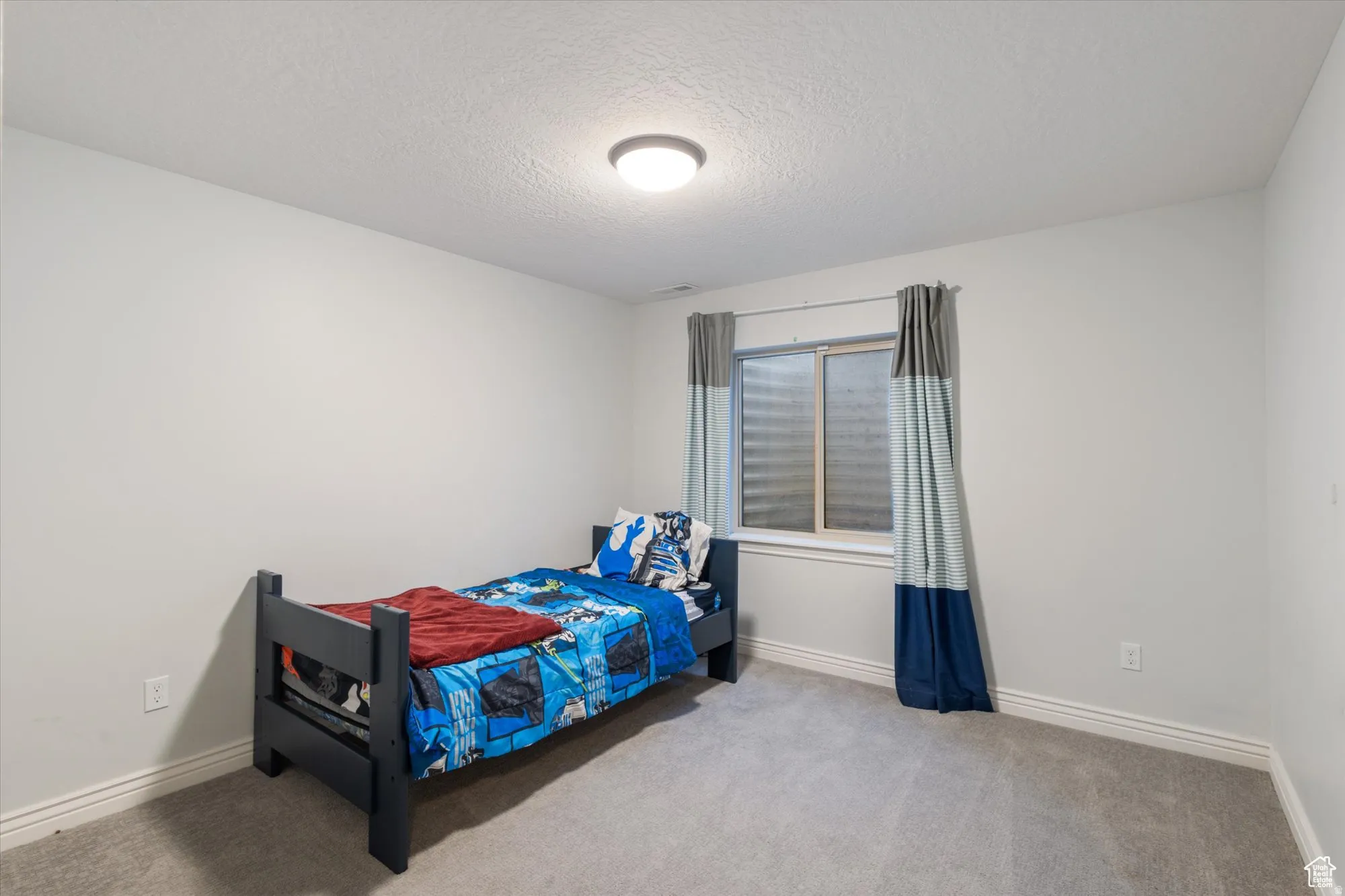 Bedroom featuring a textured ceiling and carpet floors