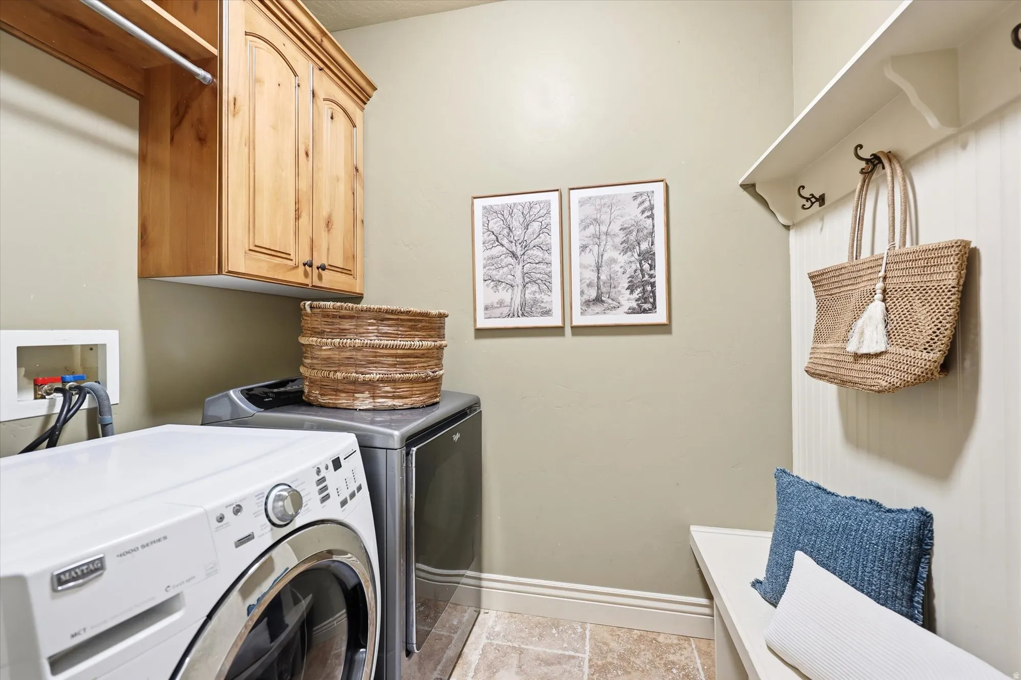 Laundry area featuring separate washer and dryer and cabinet space