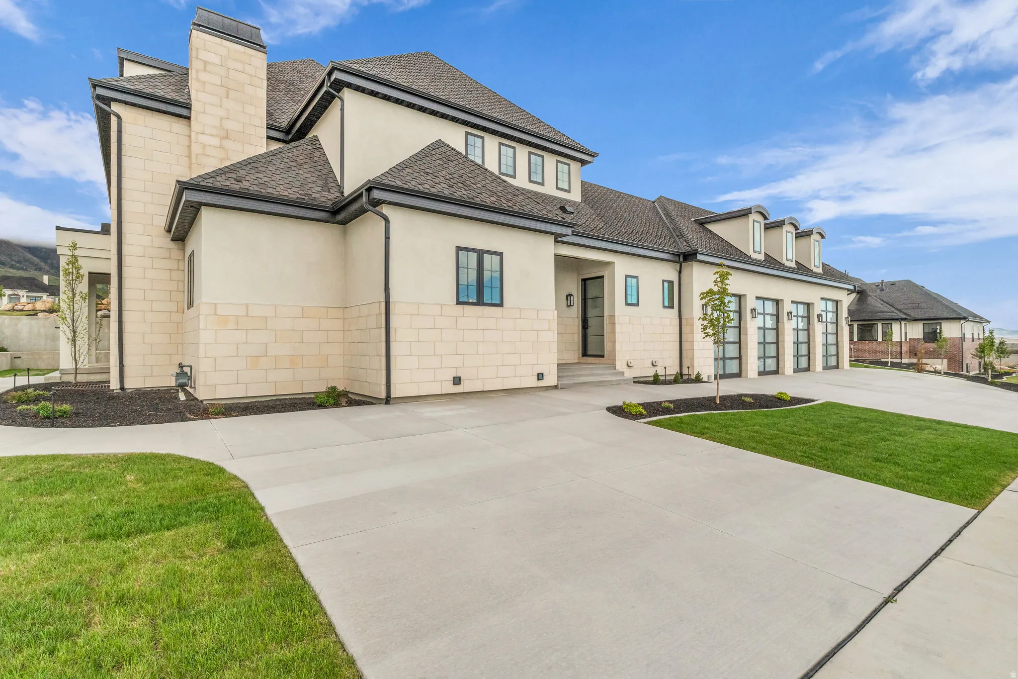 View of front of house with stucco siding, a front lawn, a shingled roof, driveway, and a chimney