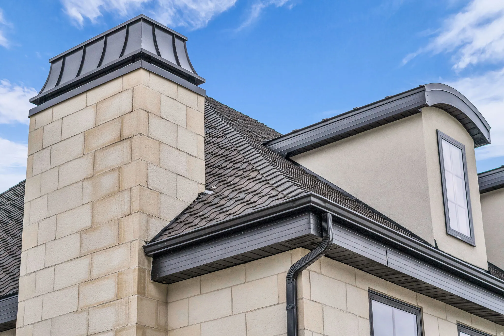 Exterior view of gutters, a downspout, and stucco siding