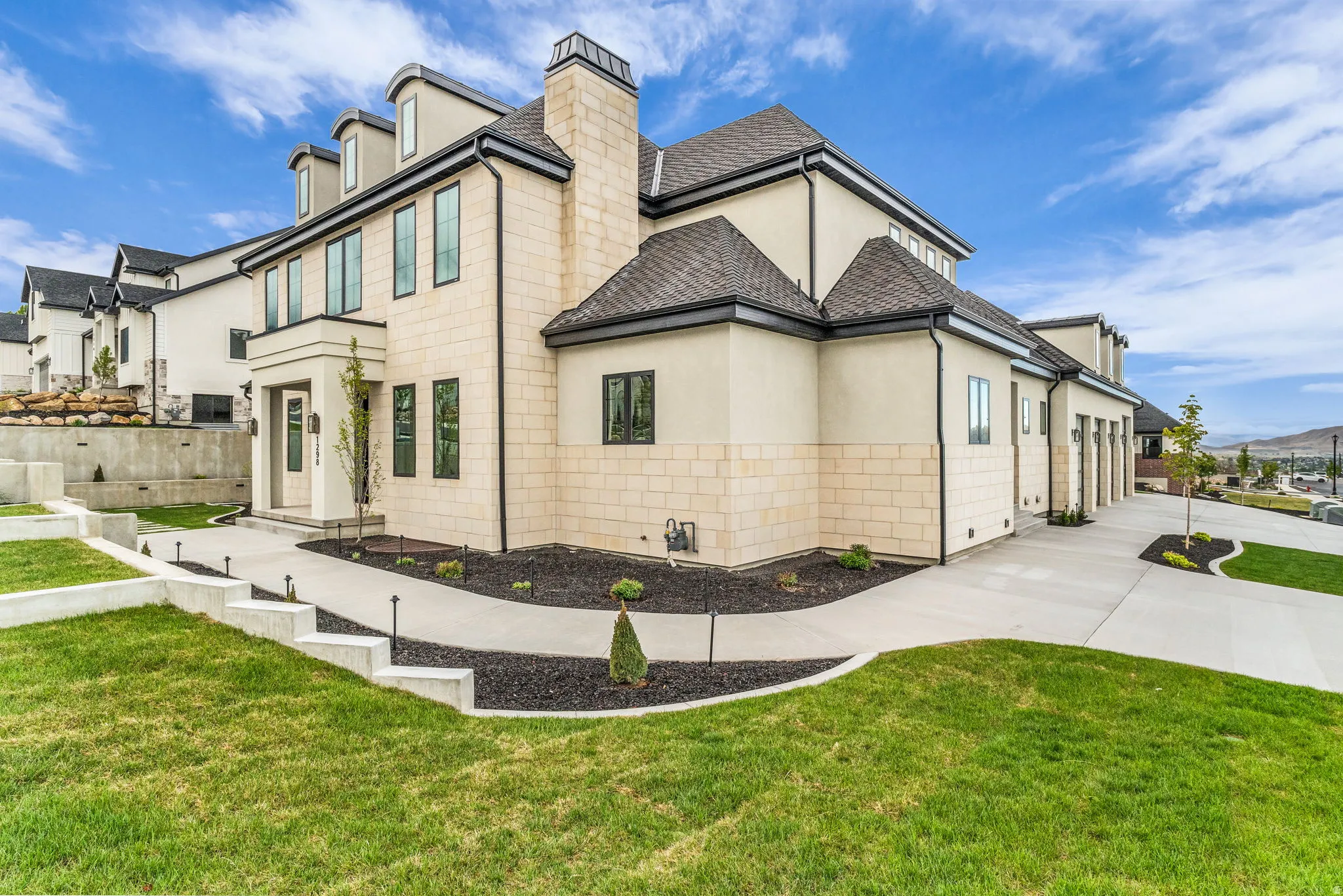 View of side of property with a lawn, stucco siding, concrete driveway, and a chimney