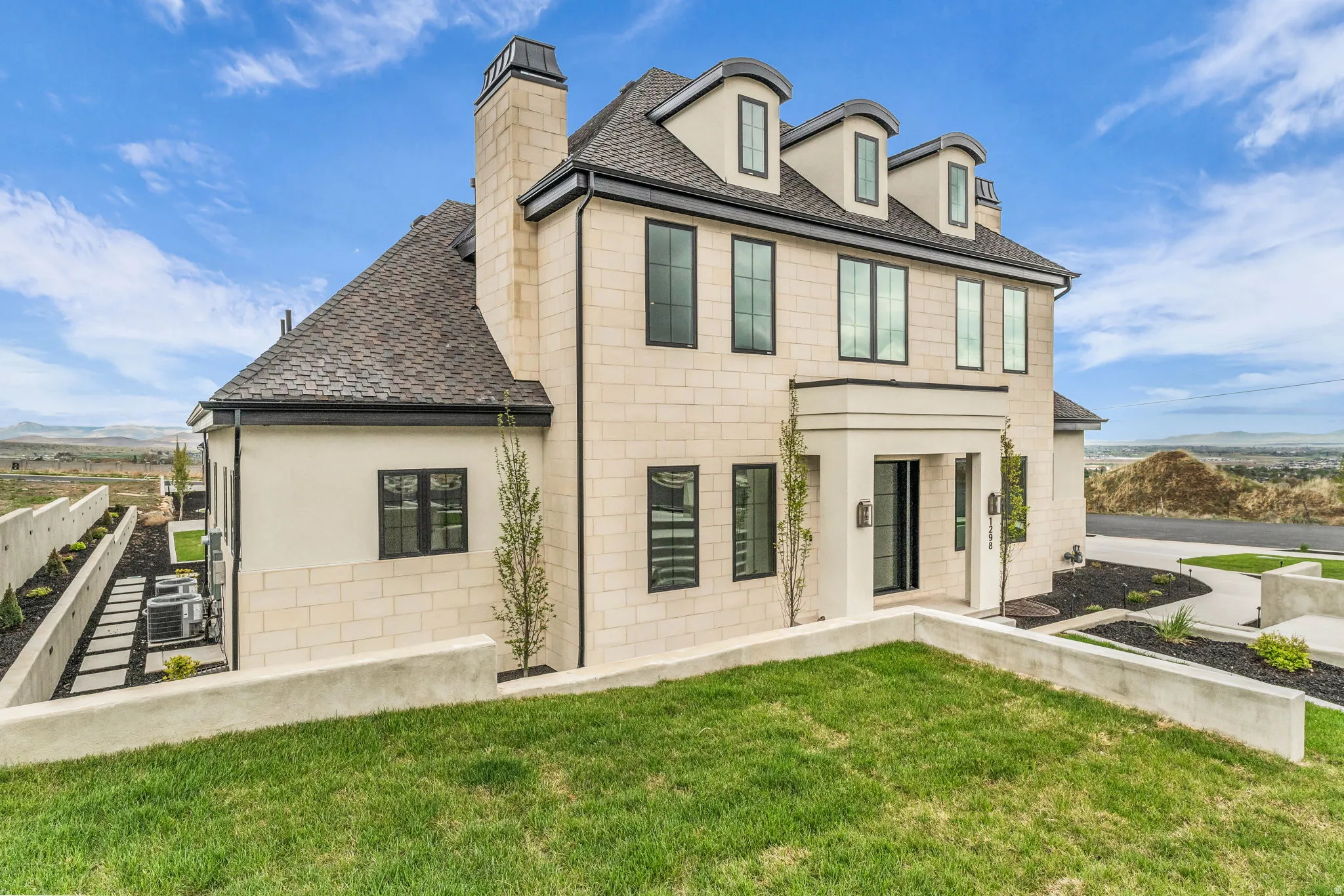 Back of property with a shingled roof, a mountain view, and a chimney