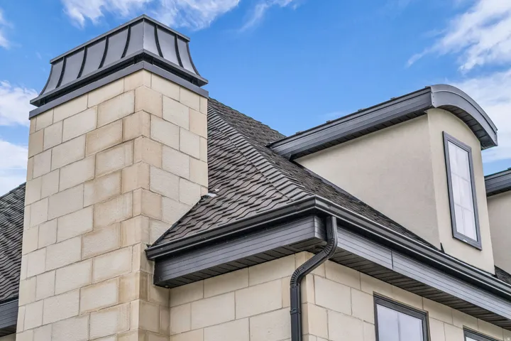 Exterior view of gutters, a downspout, and stucco siding