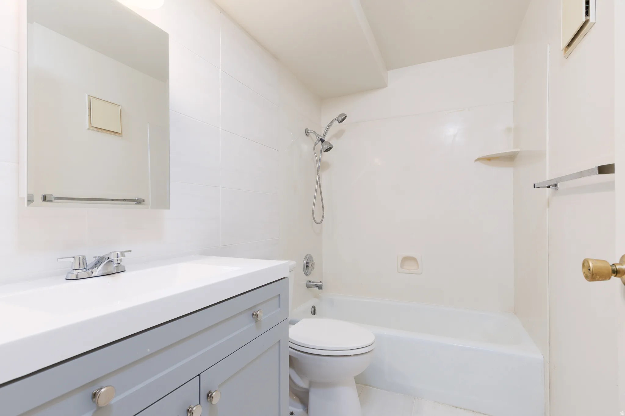 Bathroom with vanity,  shower combination, and tile walls