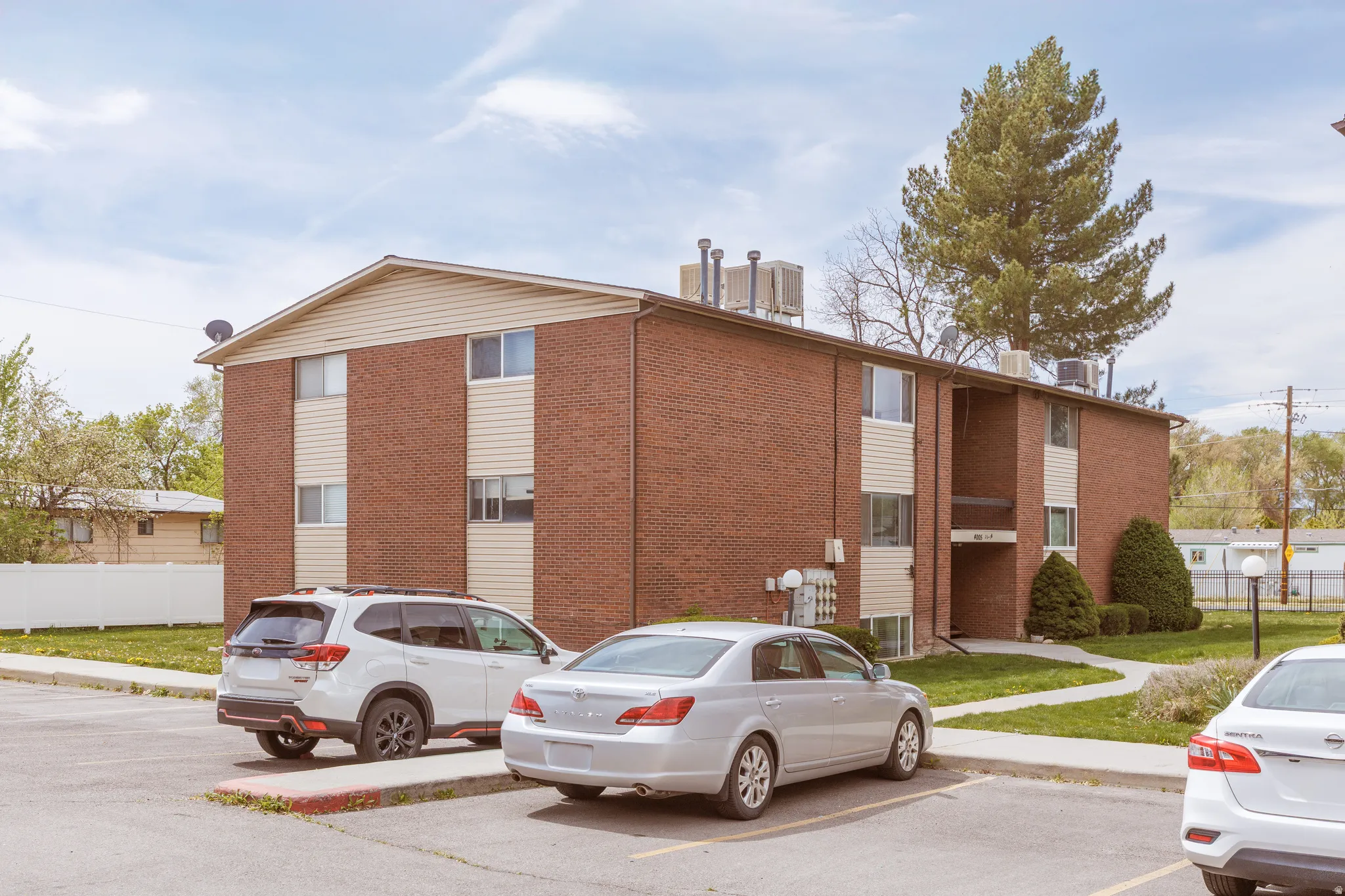 View of apartment building / complex with uncovered parking