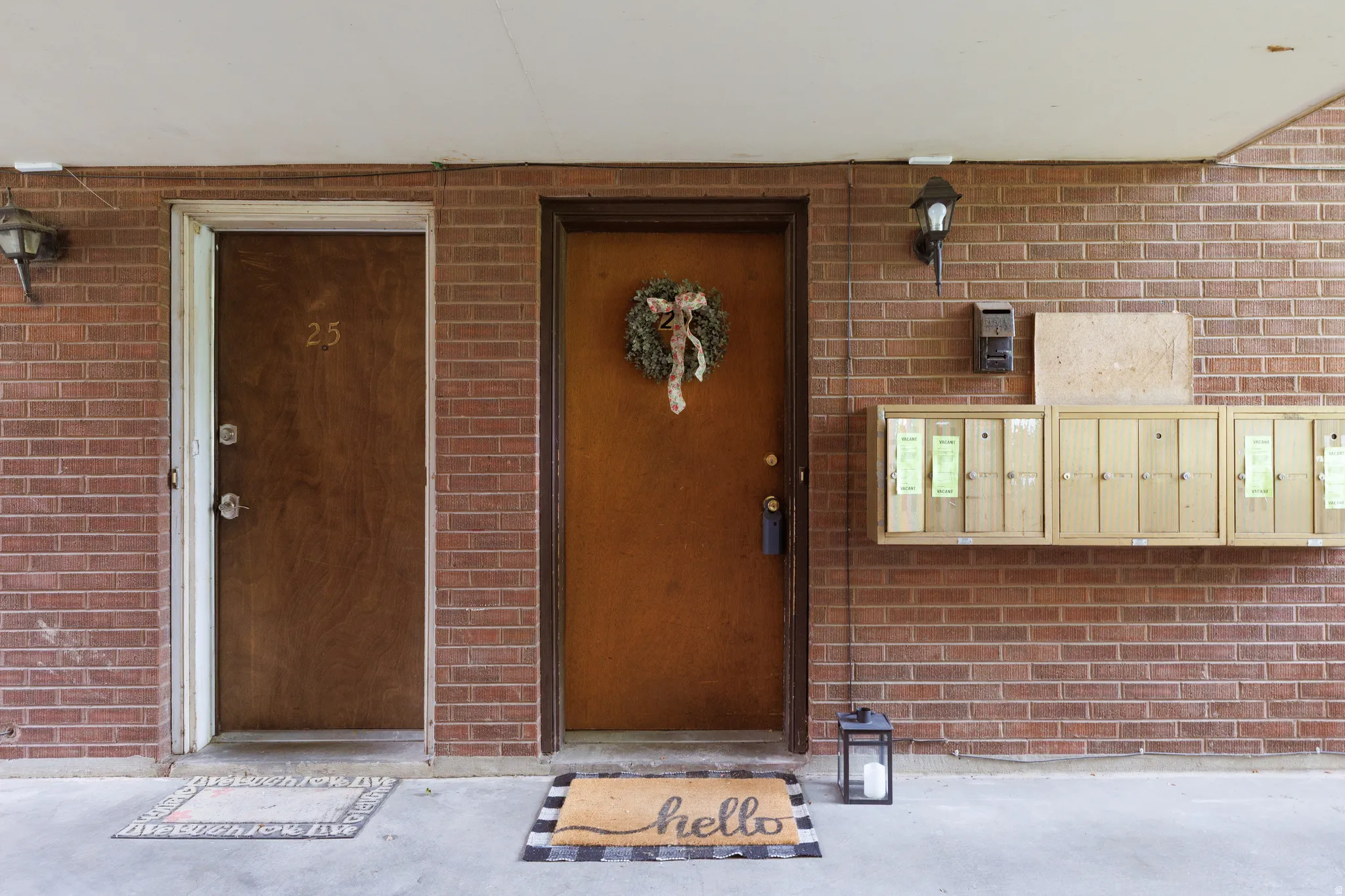 Brick exterior with covered entryway featuring two brown doors