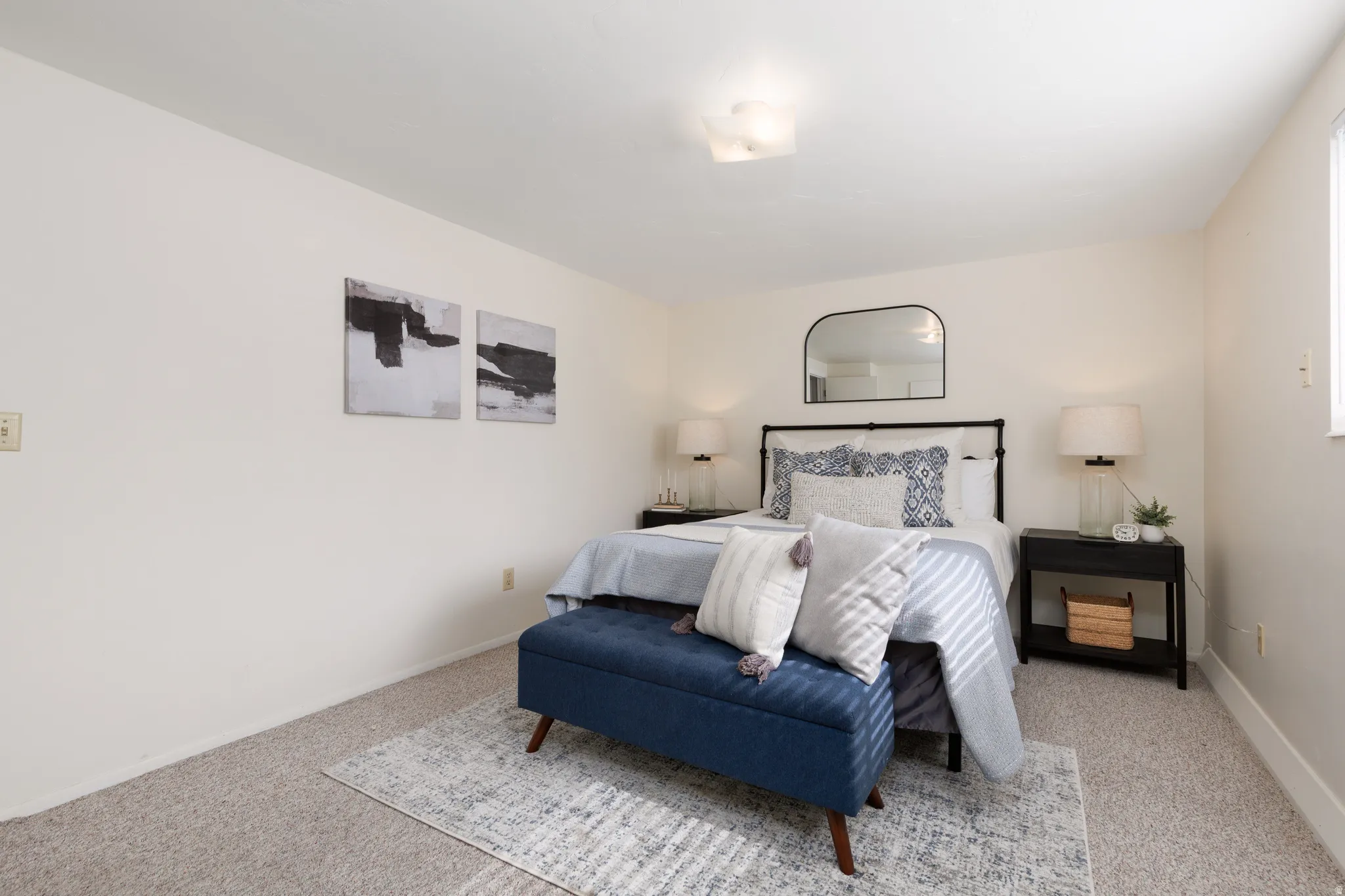 Neutral-toned bedroom featuring wall-to-wall carpeting and a ceiling-mounted light fixture