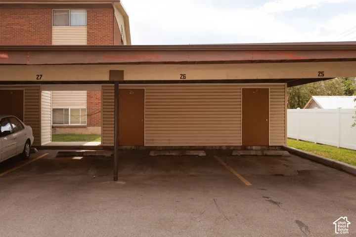 Covered parking structure featuring designated parking spaces and outdoor storage