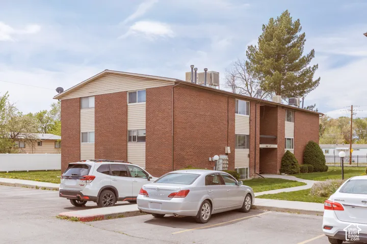 View of apartment building / complex with uncovered parking